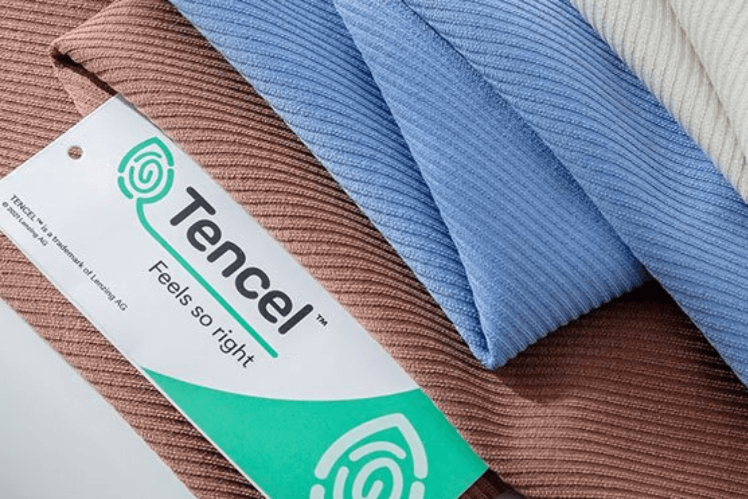 Close-up of ribbed fabric swatches in brown, blue, and cream tones, with a TENCEL™ tag reading “Feels so right.”