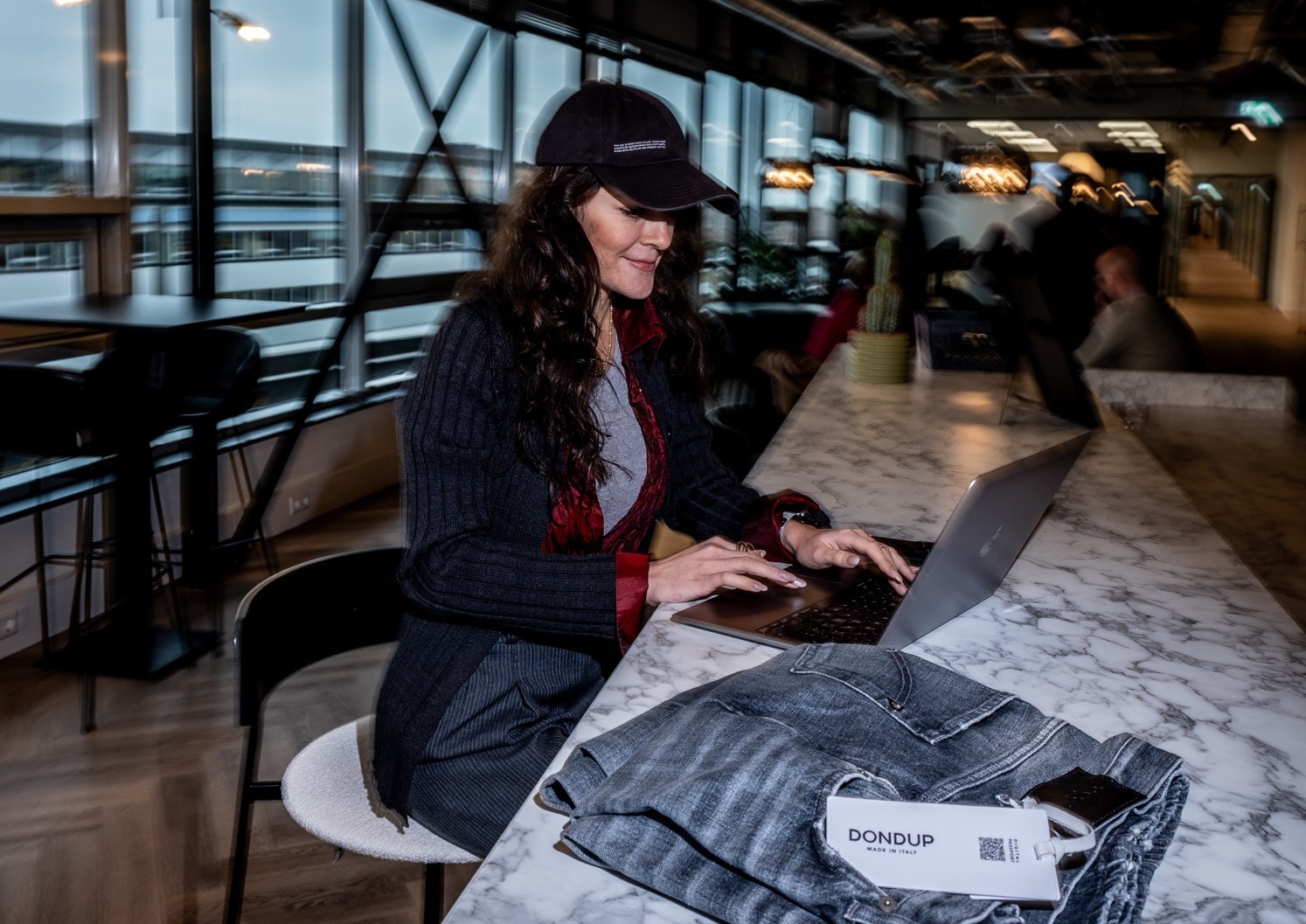 woman sitting at a bar behind laptop